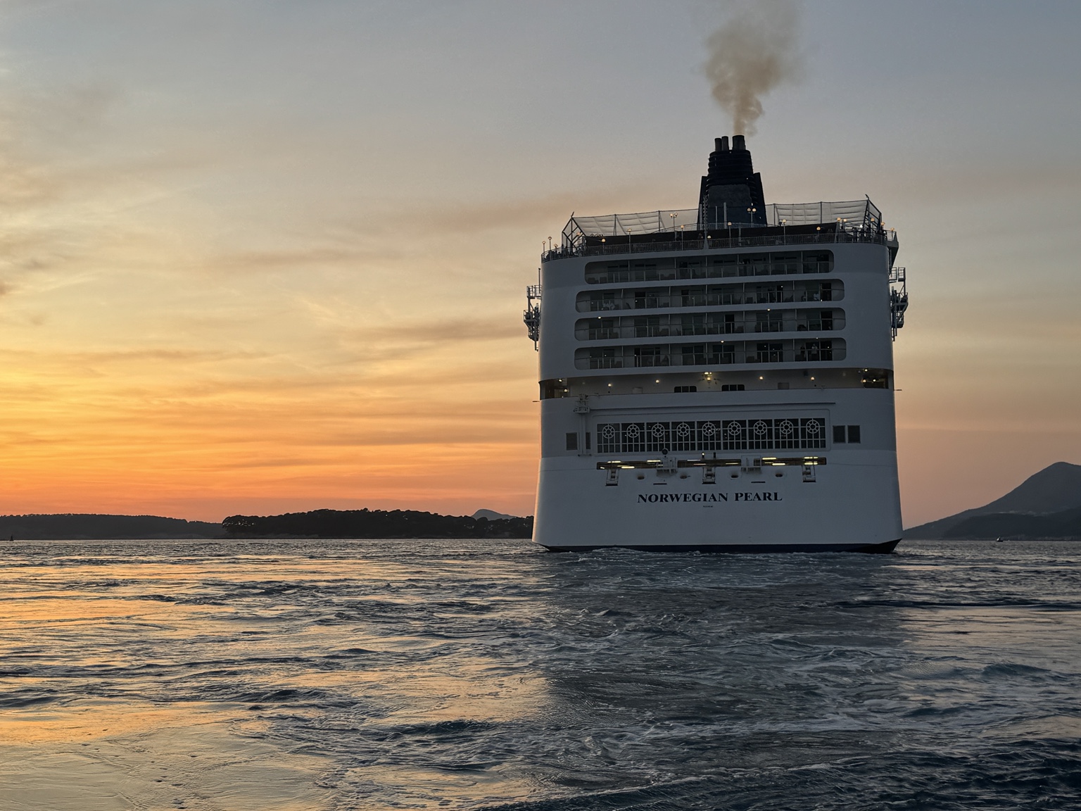 Norwegian Pearl u dubrovačkom akvatoriju pri zalasku sunca; krma s vidljivim nazivom broda. Izvorna datoteka IMG_2884.jpeg.